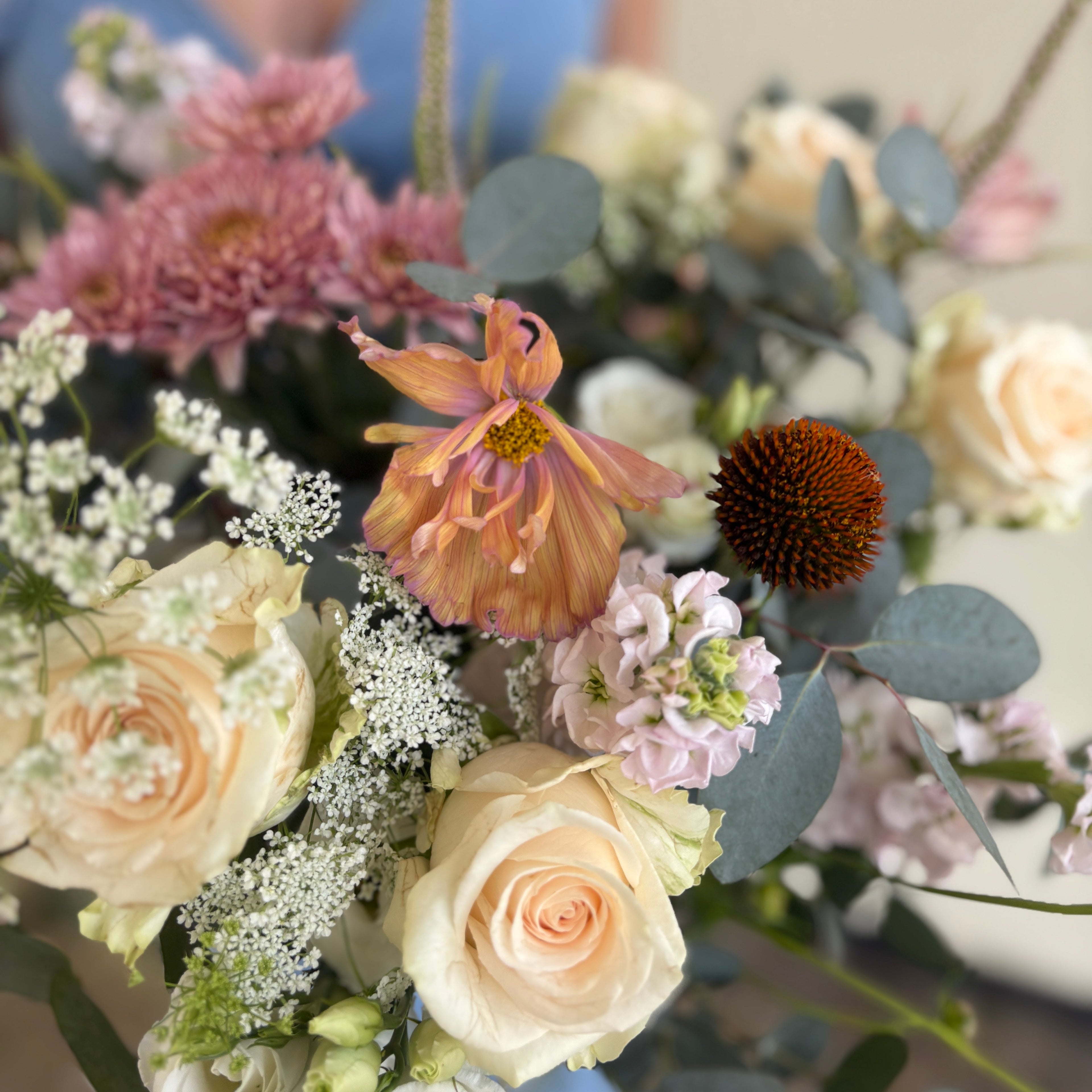 Close-up of a bouquet of flowers with a blurred person in the background